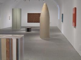 Cylindrical, bullet-shaped, and cubical sculptures in a room
