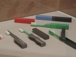 Travel toothbrushes in many colors; they fold up into the handle