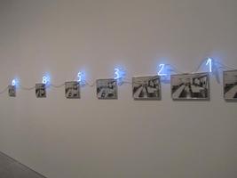 Row of black and white photographs, with a neon number in the Fibonacci sequence above the upper right corner of each photograph