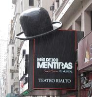 Theater sign for musical “More than 100 lies”; sign has immense derby hat perched on a corner.