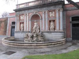 Semicircular fountain with statue of man in middle flanked by two women