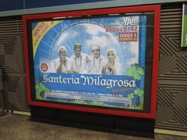 Advertisement showing four people in white robes; main text translates to “Miraculous Santeria.”