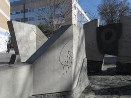 Sculpture made of slabs of stone, with picasso-like drawings etched on them.