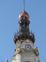Copper-colored onion dome and clock on top o building