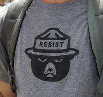 Smokey Bear wearing ranger hat with “Resist” written on band.