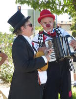 Man in top hat playing ukulele, clown playing accordion
