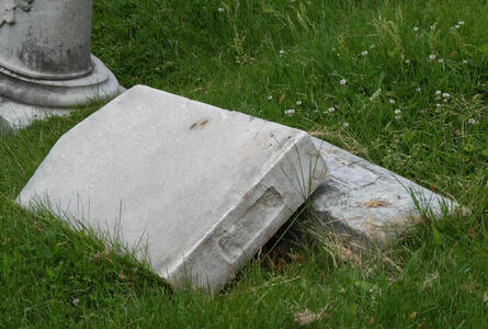 Grave with headstone that has fallen over