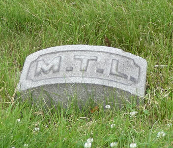 Curved headstone with initials M.T.L.