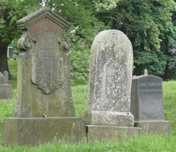 Three gravestones; two of which are faded