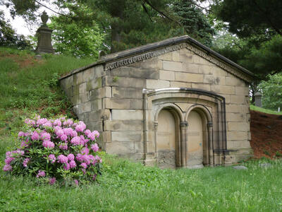 Mausoleum with purple flowers at left