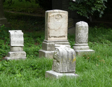 Four faded headstones and markers