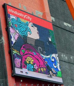 LED sign for industry city, showing woman with blue hair and purple blouse