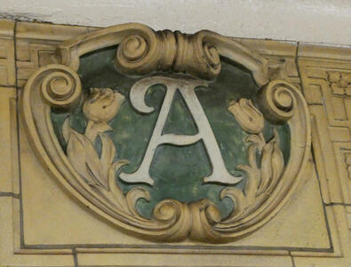 Relief with letter A and scrollwork with flower