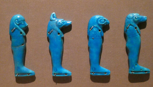 Small blue carvings of Egyptian gods in profile