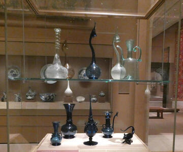 Display case of Persian glass bottles, clear and blue