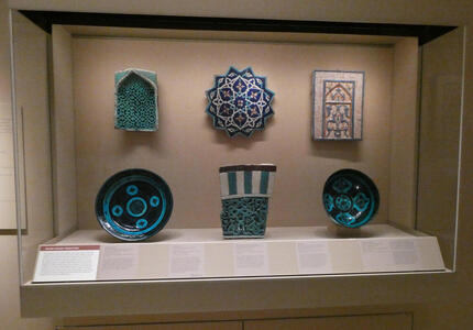 Display case of ceramic plates and tablets in blue with geometric designs