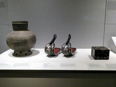 Stone incense burner at left, iron and lacquer stirrups in center, and lacquer box at right