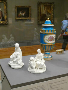 Two small porcelain figures of people and a large blue vase