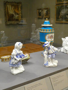 Blue-painted porcelain statues of a small boy and girl