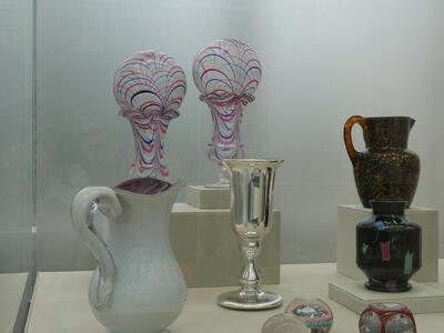 Two glass works in shape of human heads with blue and red lines painted on them