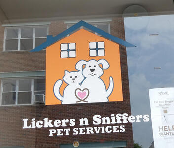 Whimsical cat and dog in front of a house. Text: Lickers n Sniffers Pet Services