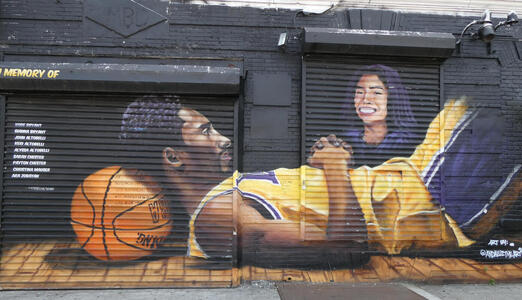 Wall art memorial to Kobe Bryant and daughter Gianna; Kobe is reclining with a basketball under his head