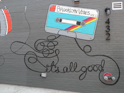 Tape cassette labeled Brooklyn Vibes, with tape spilling out of cartridge, spelling “it’s all good”