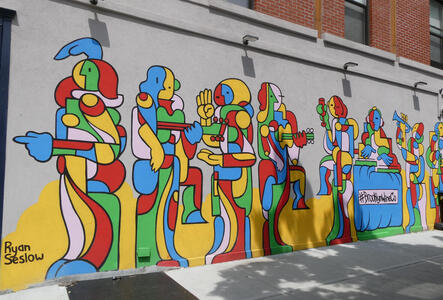 Mural; people made from primary colored geometric shapes dancing, drinking, and playing musical instruments.