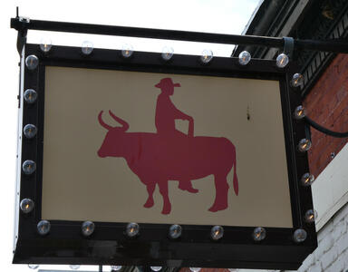 Cowboy sitting on bull, facing backwards