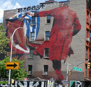 Multi-story wall painting of man in red coat waving a red white and blue flag like a matador would