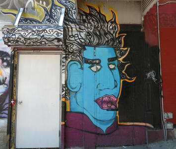 Man with blue face, pink lips, and hair consisting of looped lines