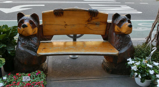Wooden bench being “held” by two carved wooden bears