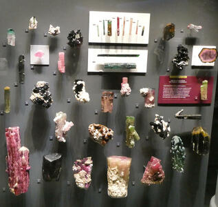 Display of mostly red minerals of tourmaline family