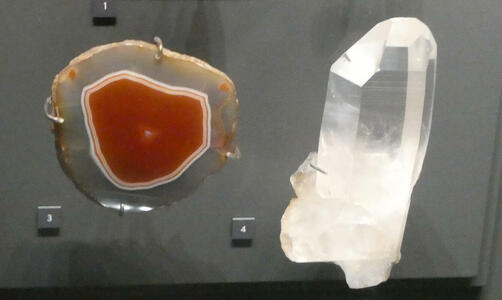 cross-section of red quartz next to crystl of clear quartz