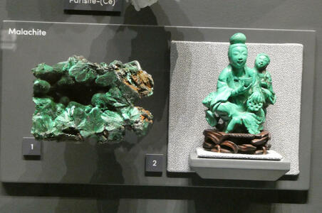 At left, raw malachite; at right, carving of woman holding a bowl