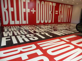 Huge lettering on walls and floor: “Belief + Doubt = Sanity”