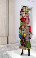 Person-shaped figure made of colored and patterned yarn
