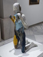 Painted plaster sculpture of kneeling woman
