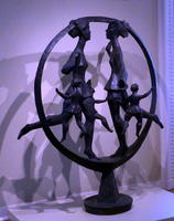 Sculpture of two women and four children; all are within a vertical hoop