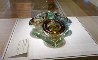 Four circular glass rings set in centers of a square of glass