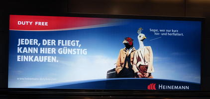 Two men with bird heads on an advert for airport's duty-free shopping