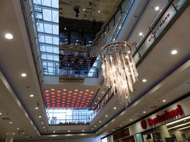 Chandelier, round orange lights, and mirror on ceiling of shopping center