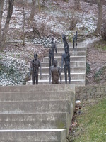 Statues of very thin men on a steep staircase