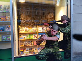 Life-size “stickers” of men with guns in bookstore window.