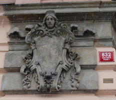 Shield-with-face relief on building
