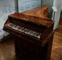 Small piano with dark brown wood
