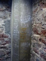 Wall of tower interior with people's names written on them.