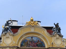 Painted arch and gold sculpture atop a building
