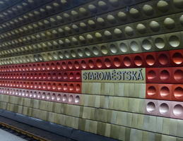 Subway wall with colored metal with circular indentations in several shades of red stripes