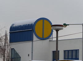Building with cylindrical blue roof; end of cylinder is yellow with vertical blue stripe down center